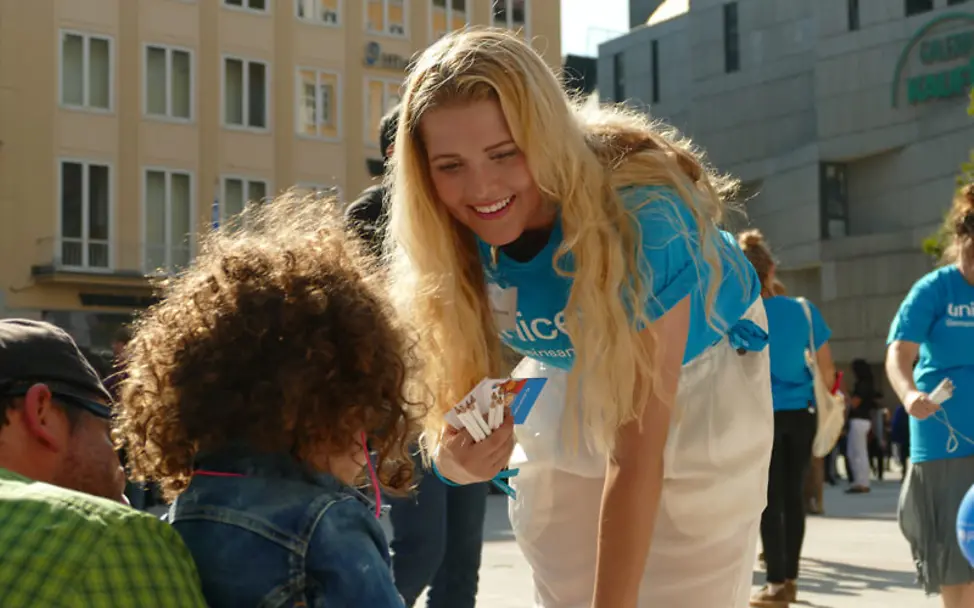 Eine UNICEF-Engagierte spricht mit einem Kind | © UNICEF/Florian Rottmayr Eine UNICEF-Engagierte spricht mit einem Kind