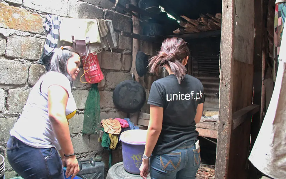 Sherry zeigt die kleine Kochnische hinter dem Wohnraum. | © UNICEF DT/Mäusbacher Gesundheit: Sherry zeigt die kleine Kochnische hinter dem Wohnraum.