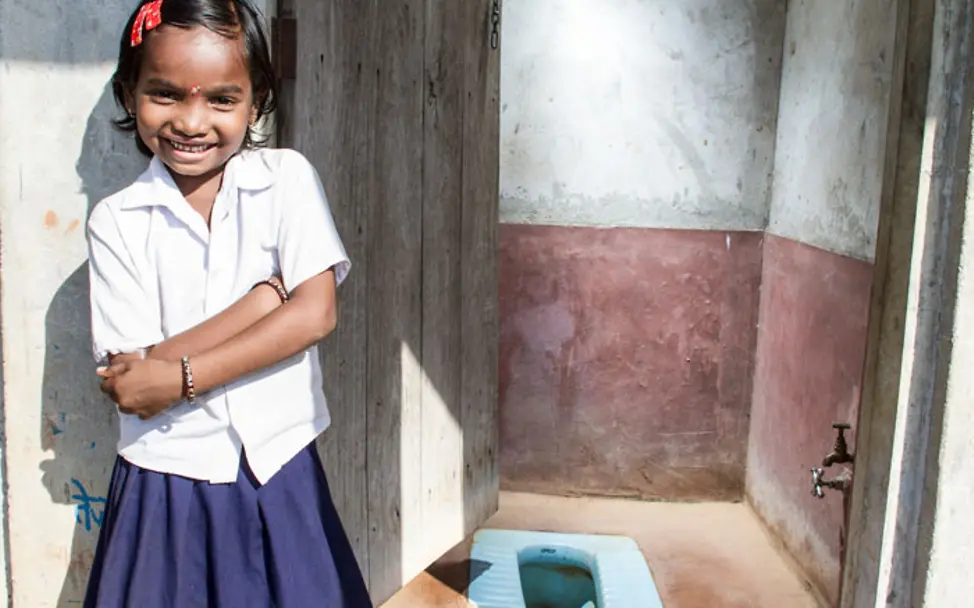 Vaishnavi zeigt ihre Familien-Toilette | © UNICEF/UN011915/Singh Vaishnavi vor der Familien-Toilette