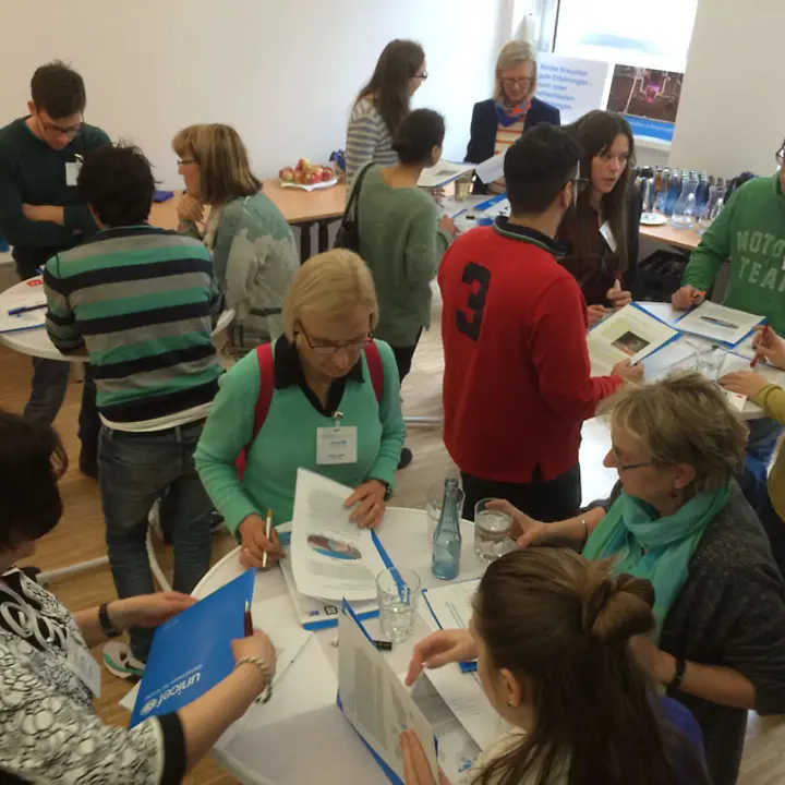 Ehrenamtliche inspizieren die neuen Tagungsmappen