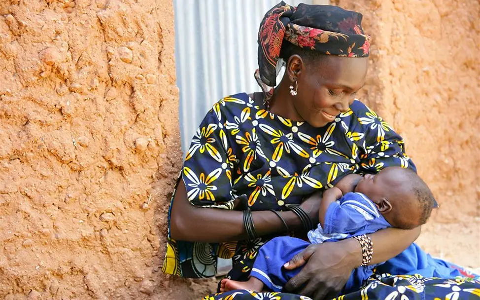 Eine Frau stillt ihr Baby in einem kleinen Ort in Niger. Eine Frau stillt ihr Baby in einem kleinen Ort in Niger.