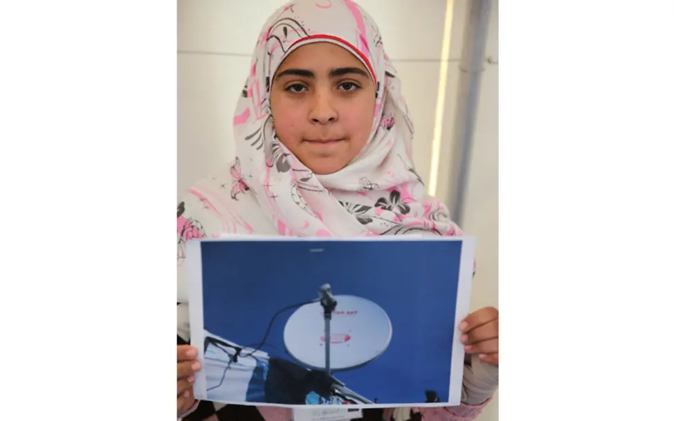 Tarin zeigt ihr Foto mit einer Satellitenschüssel | © UNICEF/Ramzi Haidar Libanon-Projektreise: Tarin zeigt ihr Ergebnis vom Fotoprojekt, eine Satellitenschüssel.