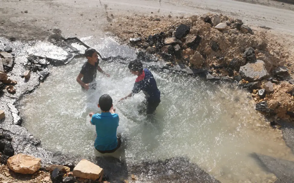 Aleppo: Kinder spielen im Wasser der zerstörten Leitung | © UNICEF/Ismail Aleppo: Kinder spielen im Wasser der zerstörten Leitung