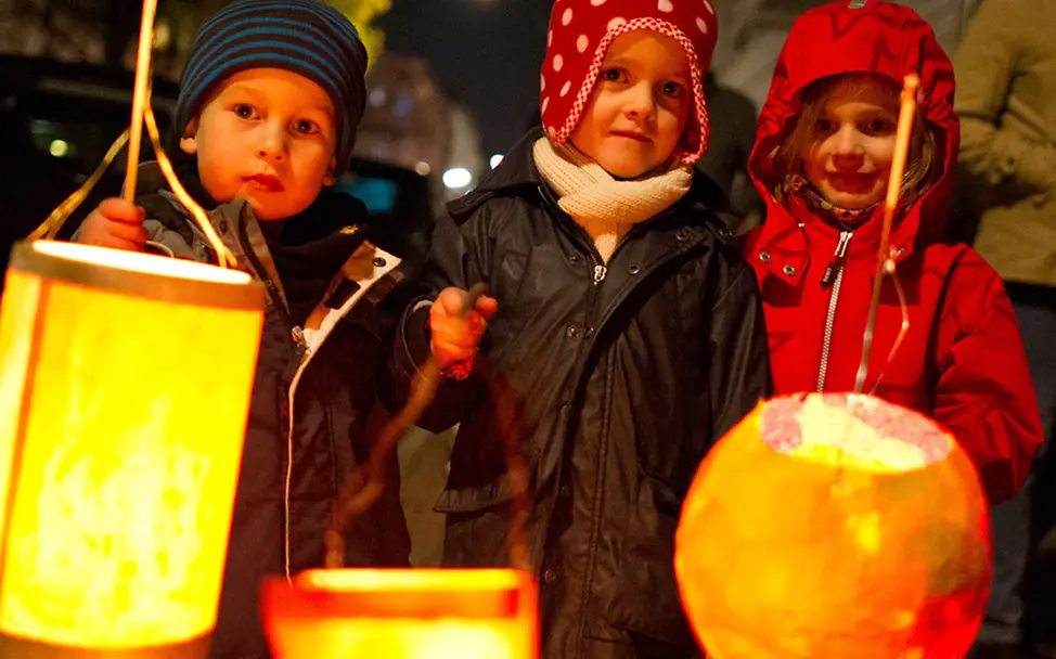 Dein Licht für Flüchtlingskinder: Drei Kinder halten selbst gebastelte Laternen