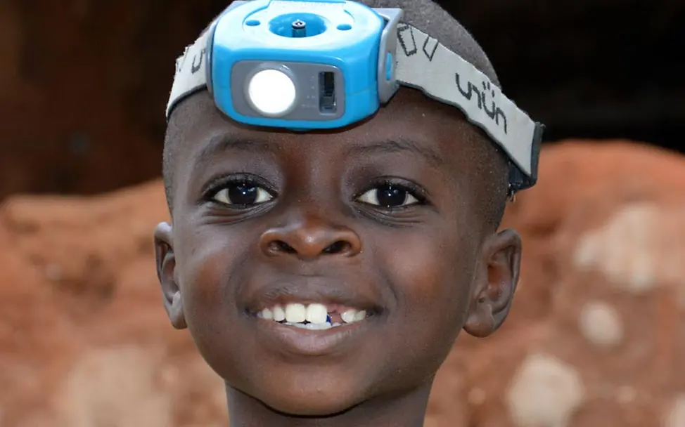 Burundi Junge Stirnlampe Burundi Innovation: Kinder und Familien profitieren von Solaranlagen und wiederaufladbaren LED-Lampen.