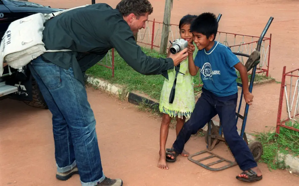 Hardy Krüger Jr zeigt zwei Kindern seine Kamera in Laos
