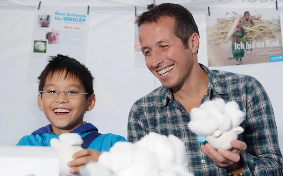 Willi Weitzel bastelt mit Kindern für eine Spendenaktion | © UNICEF DT Willi Weitzel bei der Spendenaktion "Dein Schwein für UNICEF"