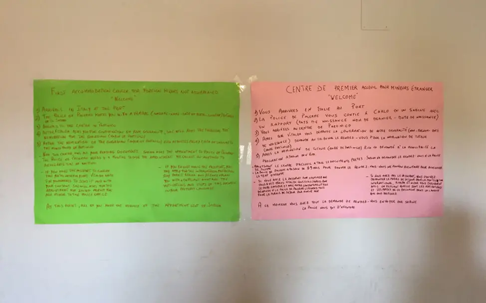 In Englisch und Französisch finden sich Informationen für Neuankömmlinge | © UNICEF/Sebastian Sedlmayr Italien: Auf zwei Zetteln stehen Informationen für Neuankömmlinge