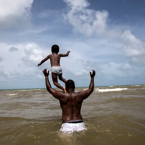 Ein Vater spielt mit seinem Sohn im Meer | © UNICEF/LeMoyne Ein Vater spielt mit seinem Sohn im Meer