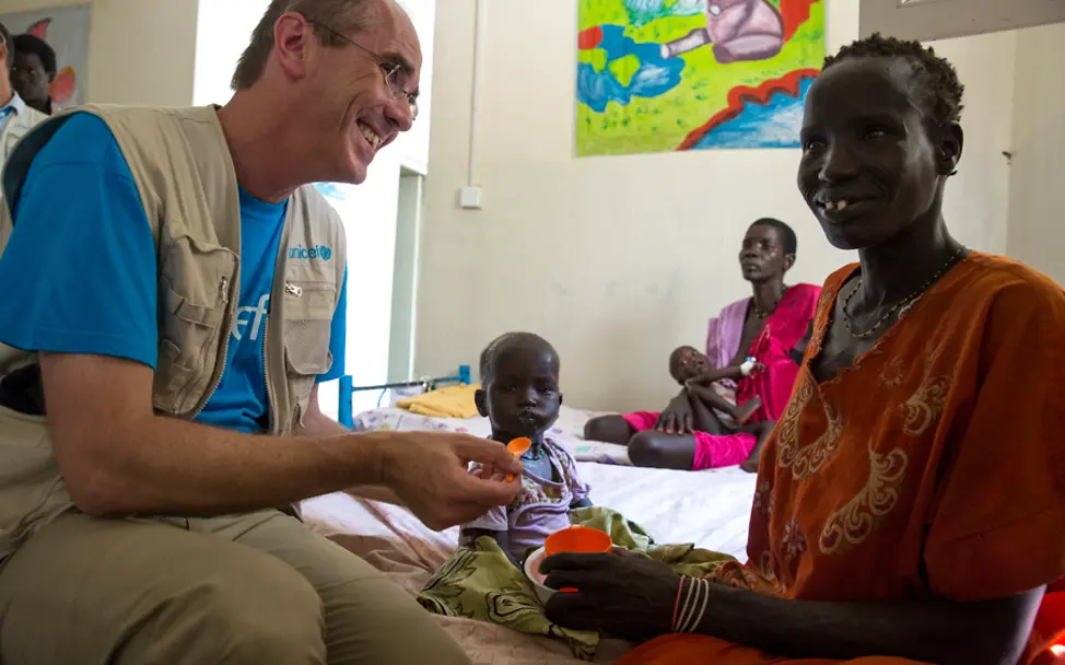 UNICEF-Geschäftsführer Christian Schneider füttert die kleine Nyanyal | © UNICEF South Sudan/Ellie Kealey Südsudan: Christian Schneider mit der kleinen Nyanyal