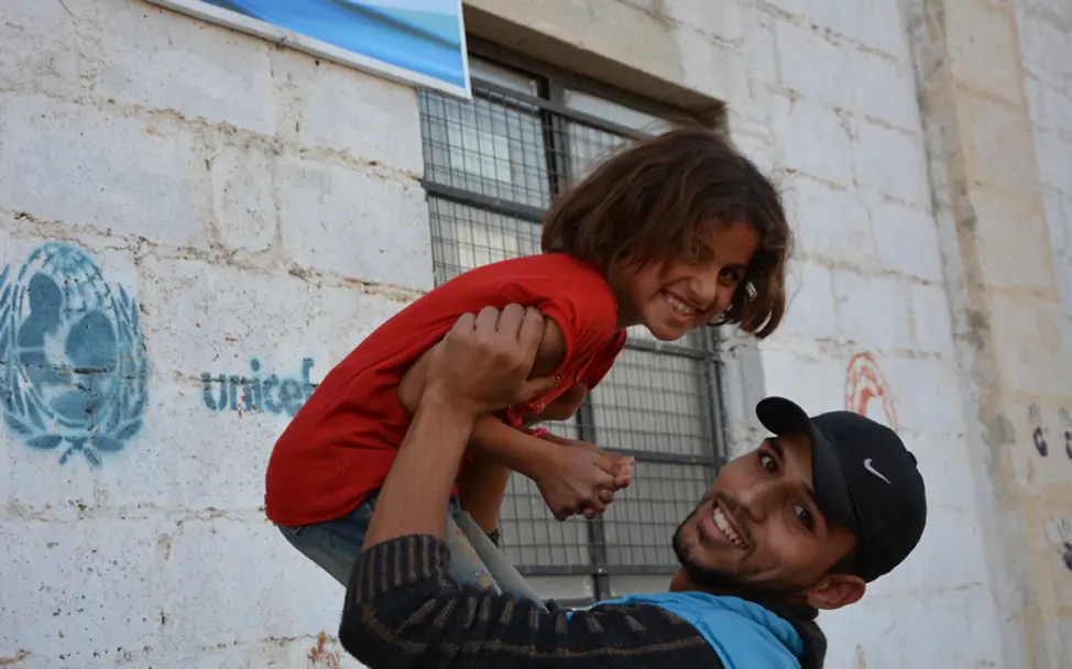 Fatima spielt mit einem ehrenamtlichen Betreuer in Jibreen | © UNICEF/Ninja Charbonneau Syrien: Ein ehrenamtlicher Betreuer spielt mit Fatima in einem "kinderfreundlichen Ort"