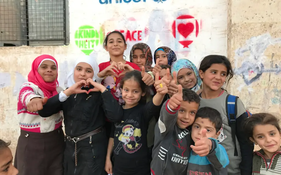 Kinder aus Syrien glauben weiter an den Frieden in ihrem Land | © UNICEF/Ninja Charbonneau Syrien Krieg: Syrisch Kinder vor Wand mit "Frieden"-Graffitis