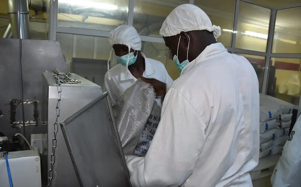 Mitarbeiter der Plumpynut-Fabrik mischen Rohstoffe zusammen. | © UNICEF/Claudia Berger Mitarbeiter der Plumpynut-Fabrik mischen Rohstoffe zusammen.