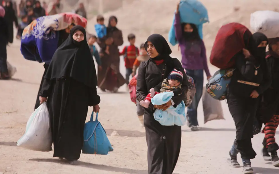 Syrien: Auf der Flucht trägt eine Mutter ihr Kind auf dem Arm