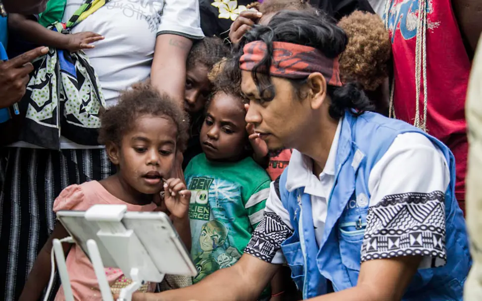 Die Steuerung der Drohnen über ein Tablet ist für die Kinder besonders spannend. | © UNICEF Pacific/Kuautonga Malawi: Kinder beobachten die Steuerung von Drohnen am Tablet