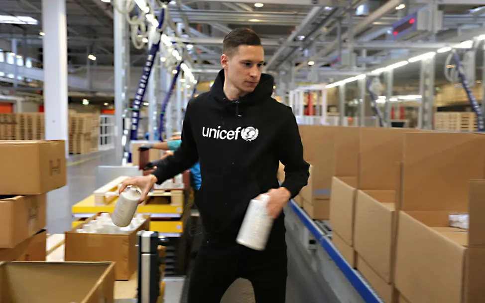 Julian Draxler packt UNICEF-Hilfspakete in Kopenhagen.