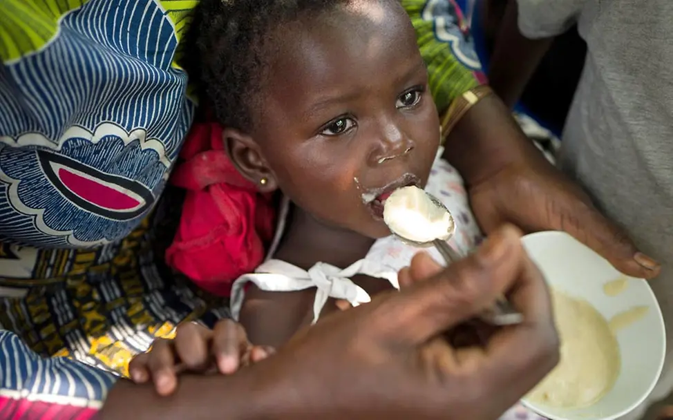 Mangelernährung: UNICEF hilft unterernährten Kindern im Kongo | © UNICEF/Dubourthoumieu Kongo: Eine Mutter füttert ihr mangelernährtes Kind mit Brei.