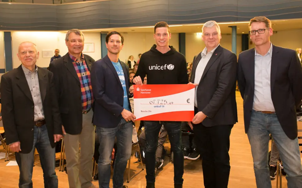 Der Spendenlauf der IGS Langenhagen hat mehr als 67.000 Euro für UNICEF-Programme eingebracht. | © IGS Langenhagen Julian Draxler hält mit strahlendem Gesicht den Scheck, der beim Spendenlauf zustande kam.