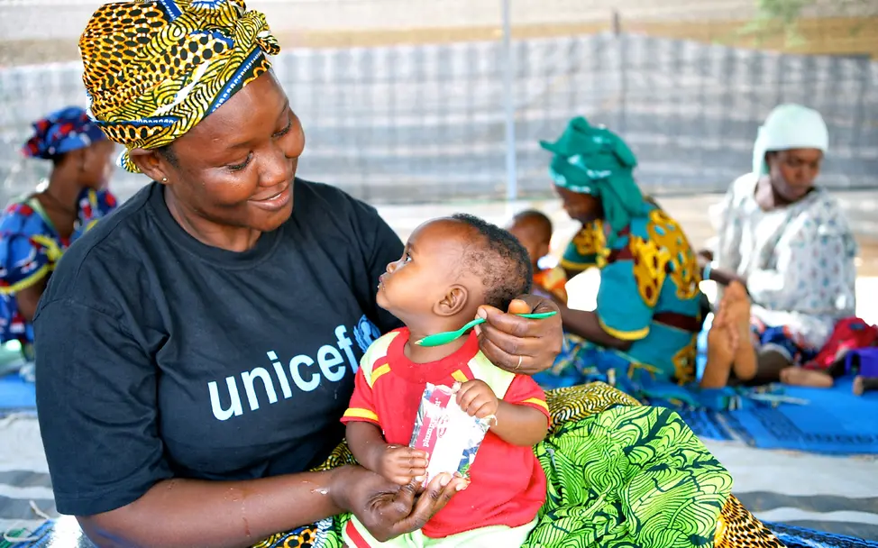 In Nigeria füttert eine UNICEF-Mitarbeiterin ein Baby mit Erdnusspaste | © UNICEF/Pirozzi Nigeria: Eine UNICEF-Mitarbeiterin füttert ein Baby mit Erdnusspaste