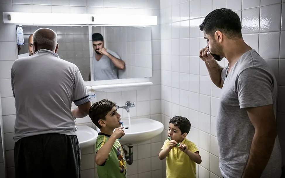 Flüchtlingsfamilie beim Zähneputzen in ihrer Unterkunft in Berlin | © UNICEF/Gilbertson VII Photo Flüchtlingsfamilie beim Zähneputzen in ihrer Unterkunft in Berlin