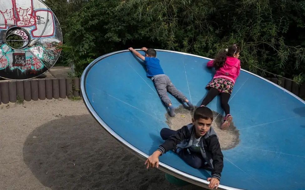 Familie Raslan aus Syrien ist seit 2015 in Deutschland. | © UNICEF/Gilbertson VII Photo Drei geflüchtete Kinder spielen auf einem Spielplatz