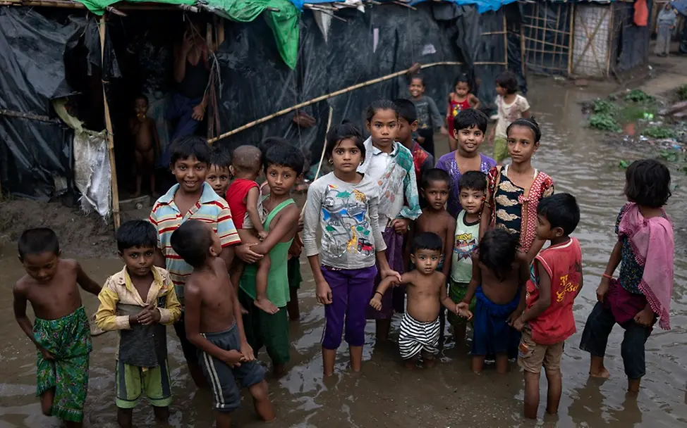 Die Kinder im Rohingya Flüchtlingslager in Cox's Bazar stehen im Wasser. | © UNICEF/Soko Rohingya Flüchtlingskinder stehen im Wasser.