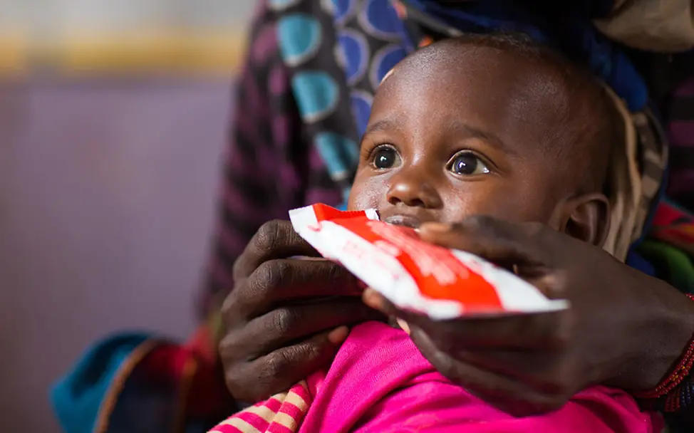 Die Erdnusspaste enthält wichtige Nährstoffe. | © UNICEF Hilfsgüter retten Leben: Ein Kind wird mit Erdnusspaste gefüttert