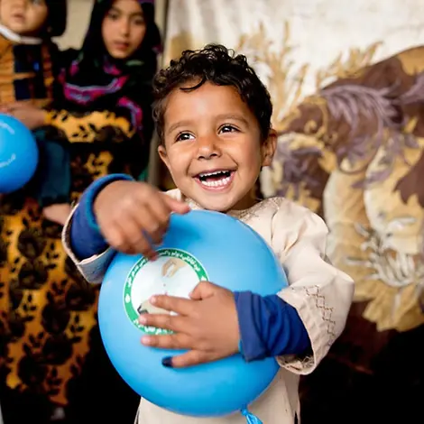 Afghanistan: UNICEF rettet Neugeborene und Mütter, z.B. mit Impfungen | © UNICEF/Hibbert Ein Junge freut sich über seinen Luftballon.