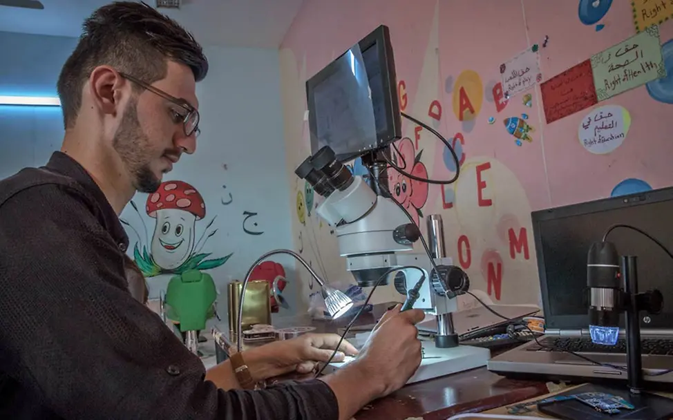 Berufsbildende Kurse: Najdamin lernt es, Handys zu reparieren. | © UNICEF/Anmar In einem Technikkurs repariert ein junger Mann ein Handy.