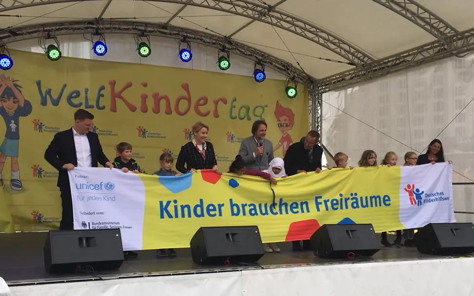 Kinder brauchen Freiräume © UNICEF Berlin Weltkindertag: Bühnenprogramm am Weltkindertag in Berlin. Es wird ein großes Banner gehalten.