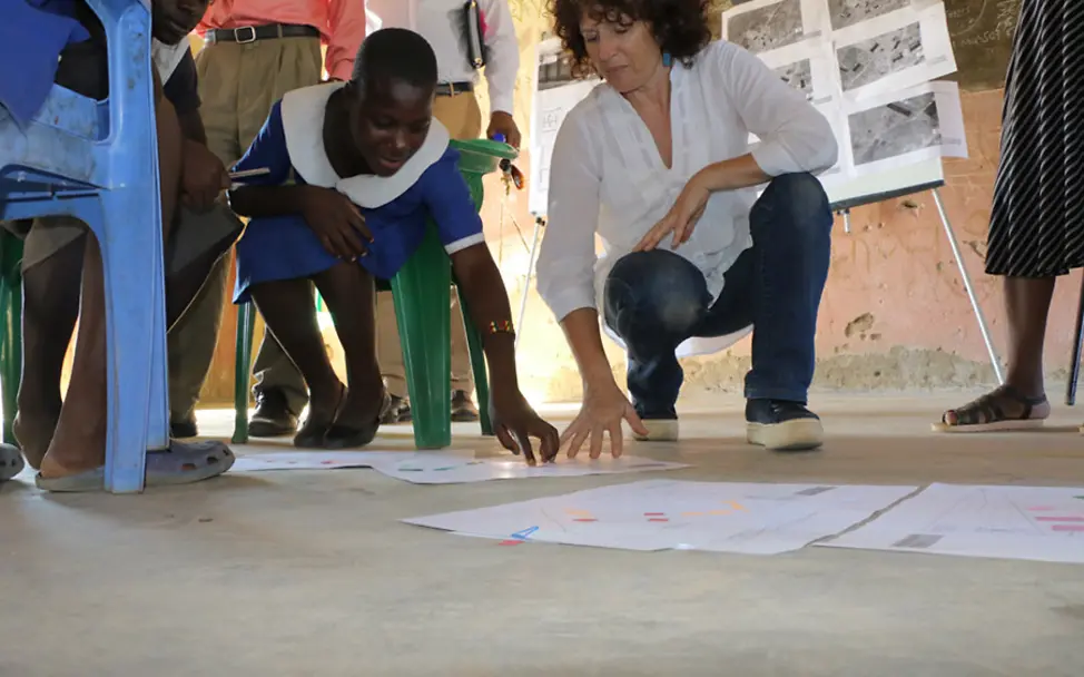 Die Meinung der Kinder zählt. | © UNICEF Malawi/2018/Jacob Nankhonya Esther und eine Mitarbeiterin schauen sich die Gebäudepläne an.