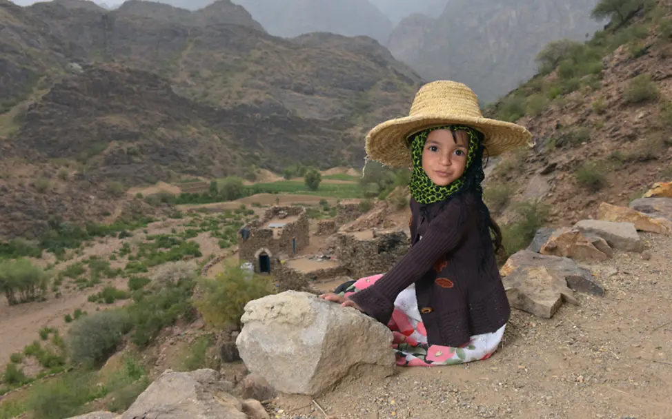 Monira aus dem Jemen sitzt oberhalb eines Tals | © UNICEF Yemen/Al-Awami Hunger im Jemen: Monira am Haus ihrer Familie