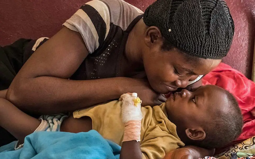 Mütter bleiben im Krankenhaus an der Seite ihrer Kinder. | © UNICEF/Sokhin Eine Mutter kuschelt mit ihrem mangelernährten Sohn.