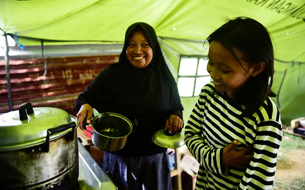 Sulawesi: Sophia und ihre Mutter bereiten das Essen an einer Kochstelle vor.