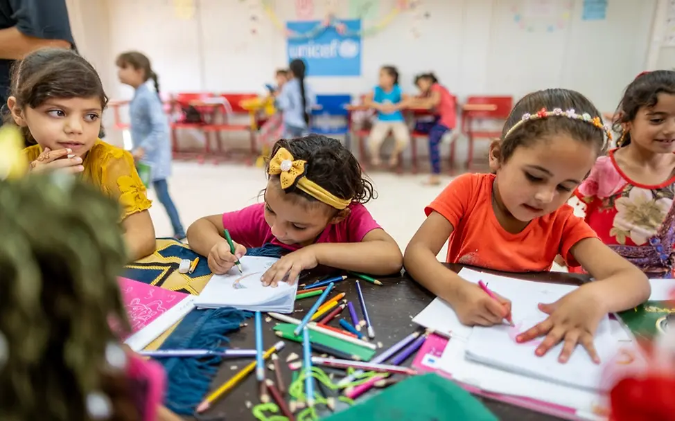 Kinder malen in einem kinderfreundlichen UNICEF-Makani-Zentrum im Flüchtlingslager Za'atari des syrischen Nachbarlandes Jordanien. | © UNICEF/Herwig Mädchen malen konzentriert an einem Tisch.