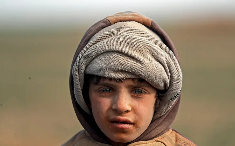 Die Gewalt der Kämpfe zwingt viele Kinder und ihre Familien zur Flucht. Drei von fünf Kindern in Syrien sind auf humanitäre Hilfe angewiesen. | © UNICEF/Souleiman Ein Porträt eines Jungen mit Kapuze und verstaubtem Gesicht.