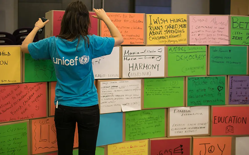 Alle Wünsche und Gedanken an einer Wand. | © UNICEF Rumänien Bukarest: Die Teilnehmer der Konferenz hängen bunte Plakate mit Wünschen und Gedanken auf.