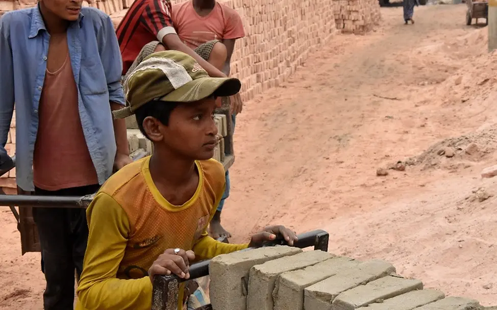 Kinderarbeit in Bangladesch: Mohamed schiebt einen karren mit Steinen.