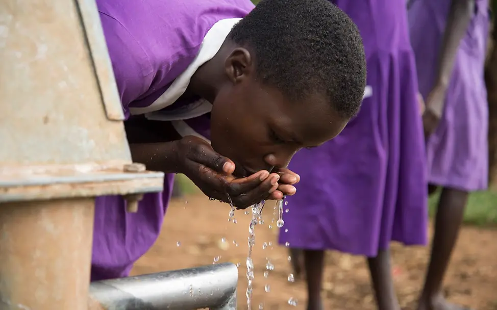 Uganda: Ein Schulmädchen trinkt Wasser aus einem Bohrloch. | © UNICEF/UN0312340/Bongyereirwe Ein Schulmädchen trinkt Wasser aus einem Bohrloch.