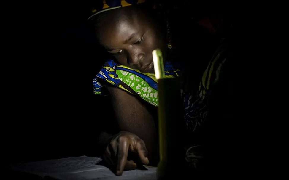 Selbst im Dunkeln wird noch fleißig gelernt. | © UNICEF/Dicko Mali: Fatoumate lernt im Schein einer Leselampe.