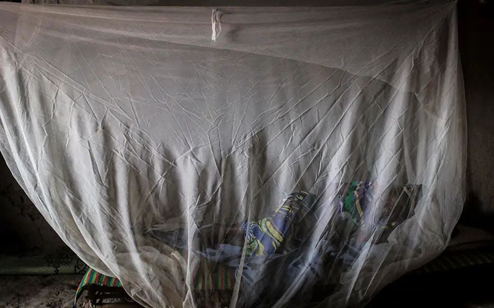 Moskitonetze bieten einen wichtigen Schutz vor übertragbaren Krankheiten. | © UNICEF/Dicko Mali: Fatoumata schläft unter einem Moskitonetz, um sich vor Stechmücken zu schützen.