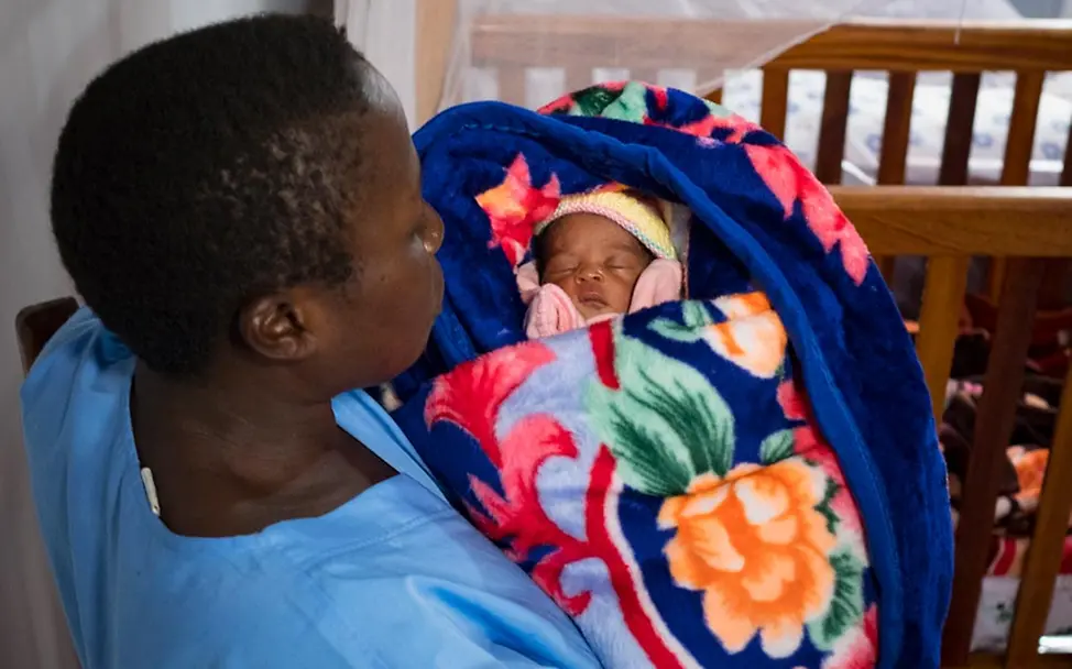 Victorines Mutter ist an Ebola gestorben. Eine Schwester kümmert sich jetzt um sie. | © UNICEF/Nybo Ebolafieber: Eine UNICEF-Helferin kümmert sich um ein von Ebolafieber betroffenes Kind.