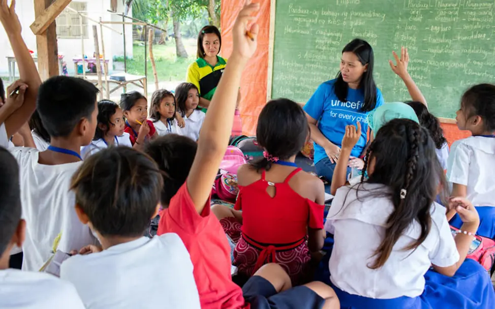 Philippinen: Schulkinder im Gespräch mit einer UNICEF-Helferin | © UNICEF/Kokic Philippinen: Schulkinder im Gespräch mit einer UNICEF-Helferin