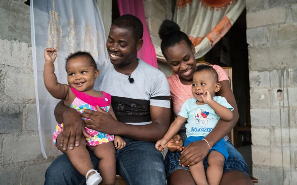 Die zwei Zwilligen spielen glücklich mit ihren Eltern | © UNICEF/UNI266153/Meddeb Haiti: Eltern spielen mit ihren Zwilligen vor ihrem Zuhause