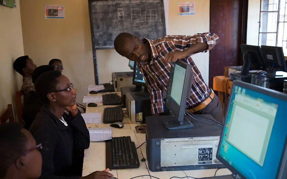 UNICEF bietet Lernzentren zur Internetbenutzung an. | © UNICEF/Prinsloo Burundi: Diodeme zeigt einer Kursteilnehmerin etwas an ihrem Computer.