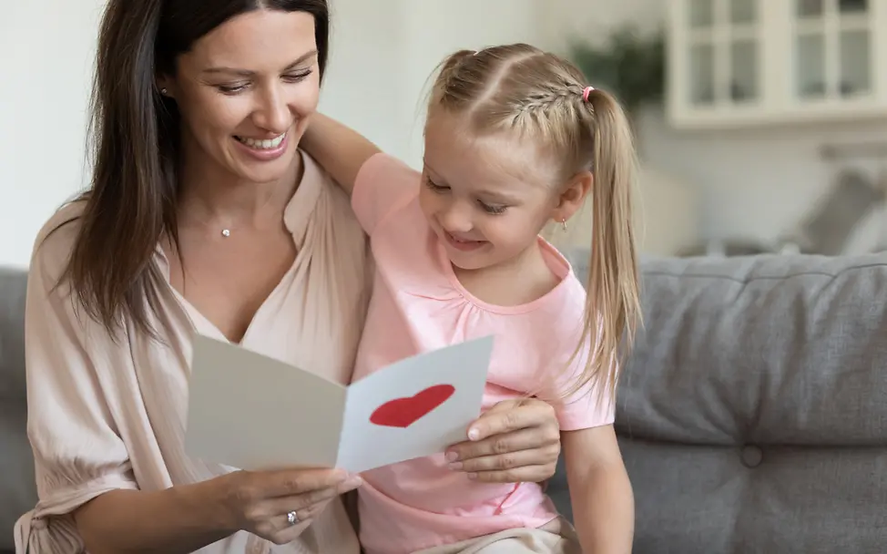 Eine Frau und ein Mädchen freuen sich über eine Grußkarte | © Shutterstock Trotz Corona in Kontakt bleiben: Eine Frau und ein Mädchen freuen sich über eine Grußkarte