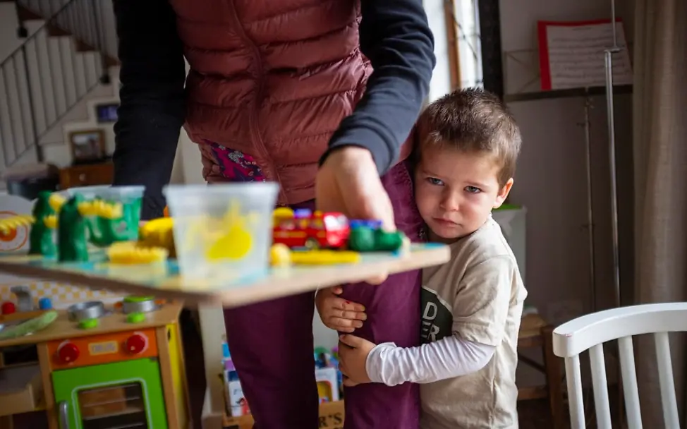 Paul klammert sich fest an das Bein der Mutter. | © UNICEF/Prinsloo Südafrika: Junge klammert sich an das Bein der Mutter.