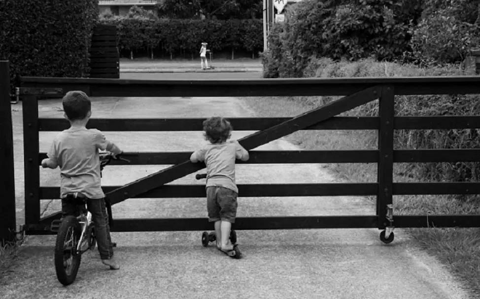 Awa und Winata kommunizieren mit einem Freund aus der Ferne. | © UNICEF/Tukiri Neuseeland: Zwei Jungen stehen vor einem großen Zaun.