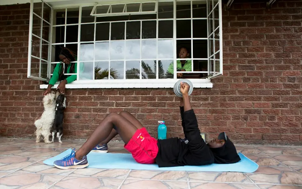 Auf der Terrasse trainiert Tapfuma mit einem Gewicht. | © UNICEF/Mukwazhi Simbabwe: Junge trainiert auf der Terrasse mit einem Gewicht.