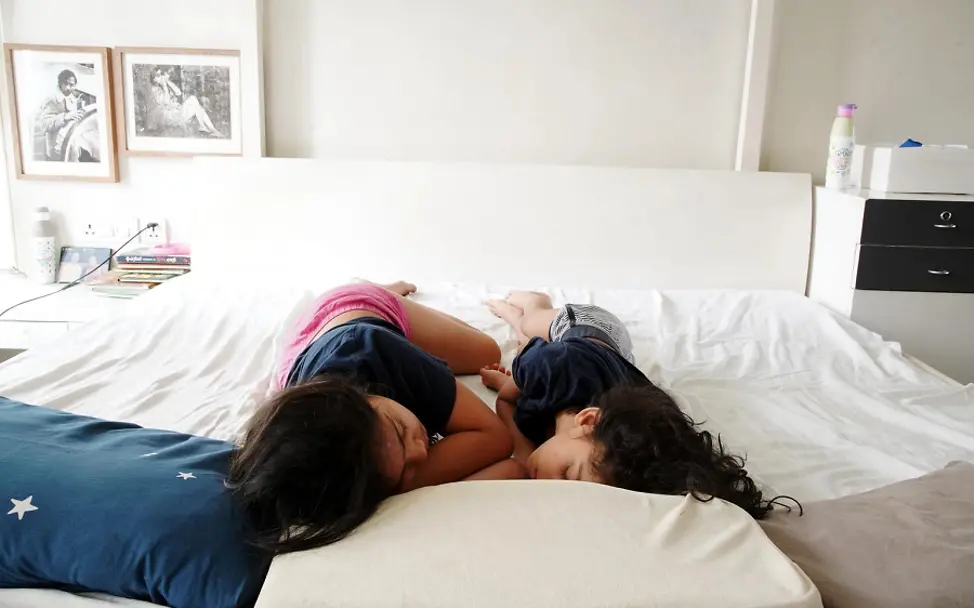 Die Mädchen schlafen tief und fest im Bett der Eltern. | © UNICEF/Khemka Indien: Zwei Mädchen schlafen zusammen im Bett der Eltern.